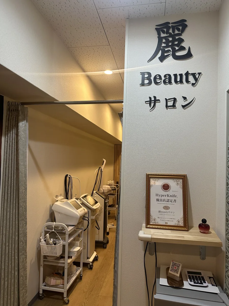 麗 Beauty サロンの看板が掲げられた店内の入口と施術スペース